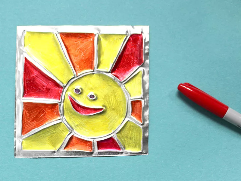 Colored markers on tin depicting the sun and rays.